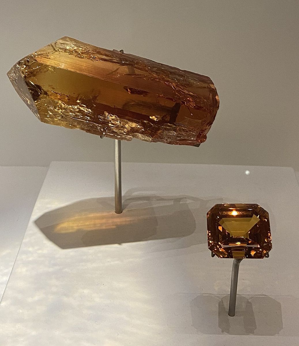 Cristal brut de topaze impériale et pierre taillée exposés au musée